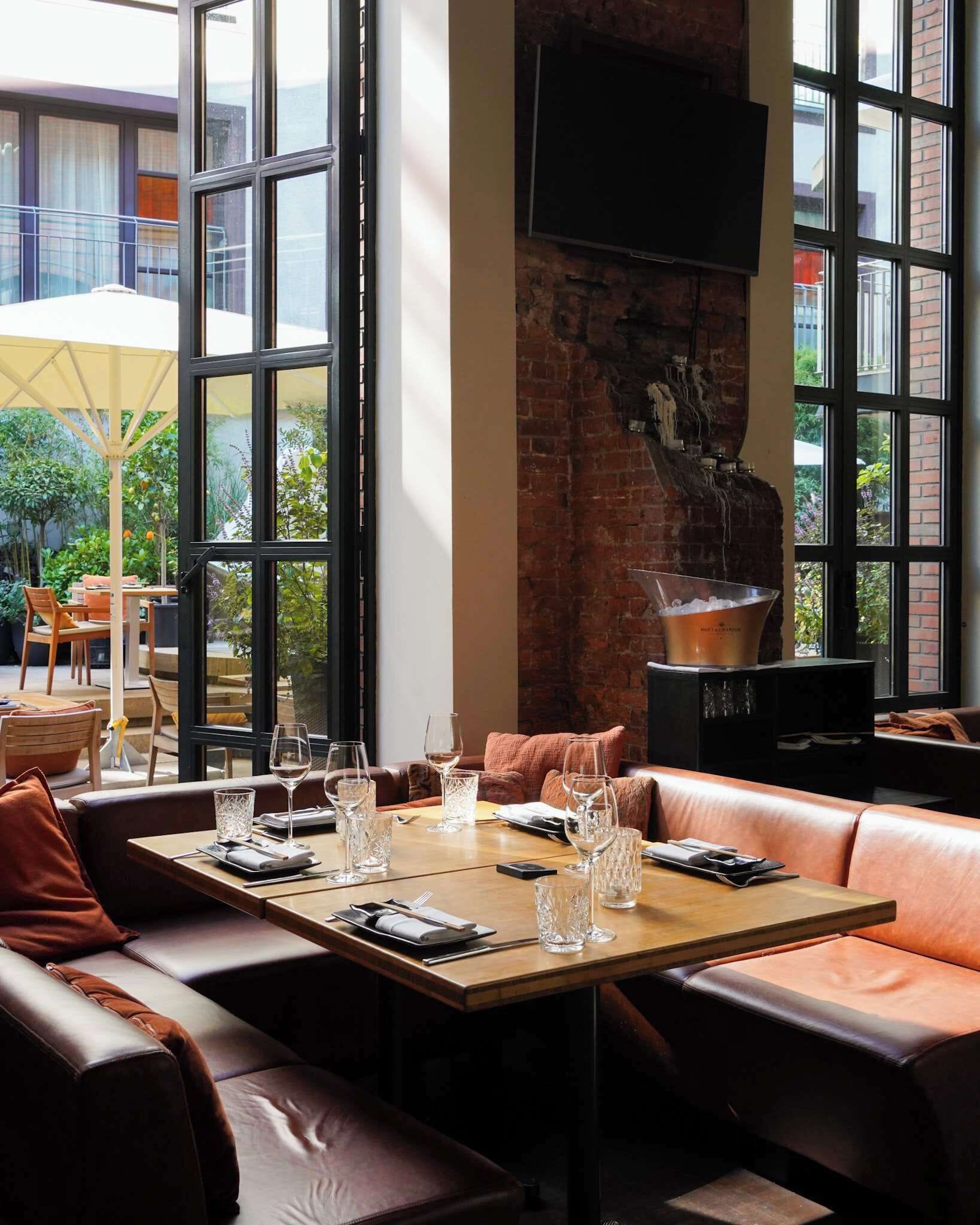 A modern dining area with a brick wall, large windows, and a fireplace.