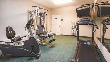 A gym with cardio machines, weight equipment, and a treadmill.