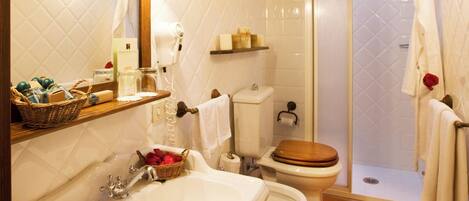 A bathroom with a sink, toilet, and shower area.