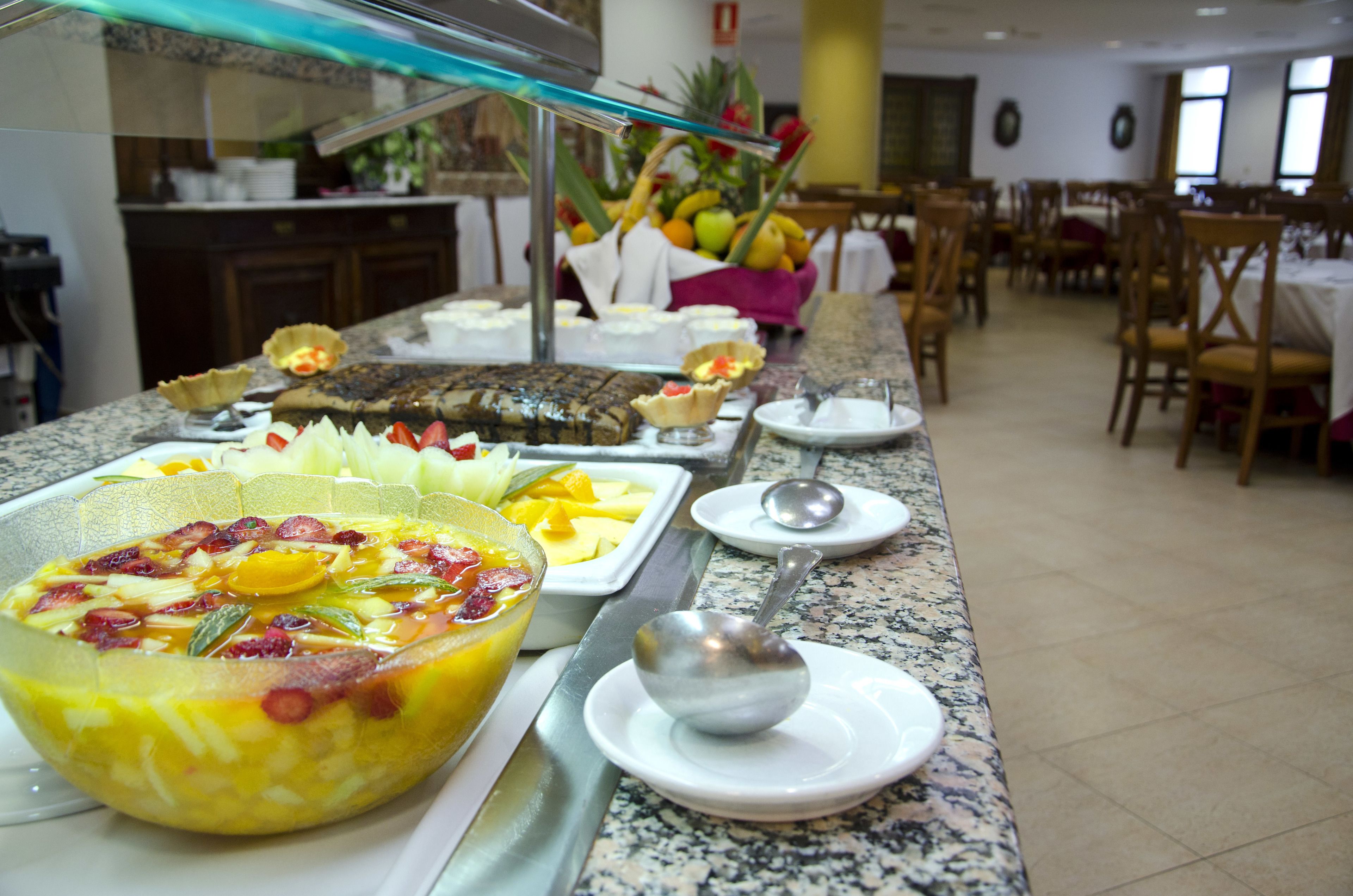 A buffet with various dishes and a fruit bowl.