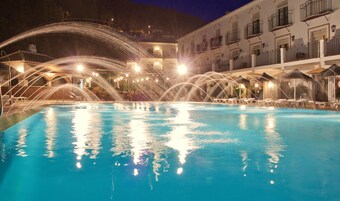 Una piscina al aire libre, sombrillas, tumbonas