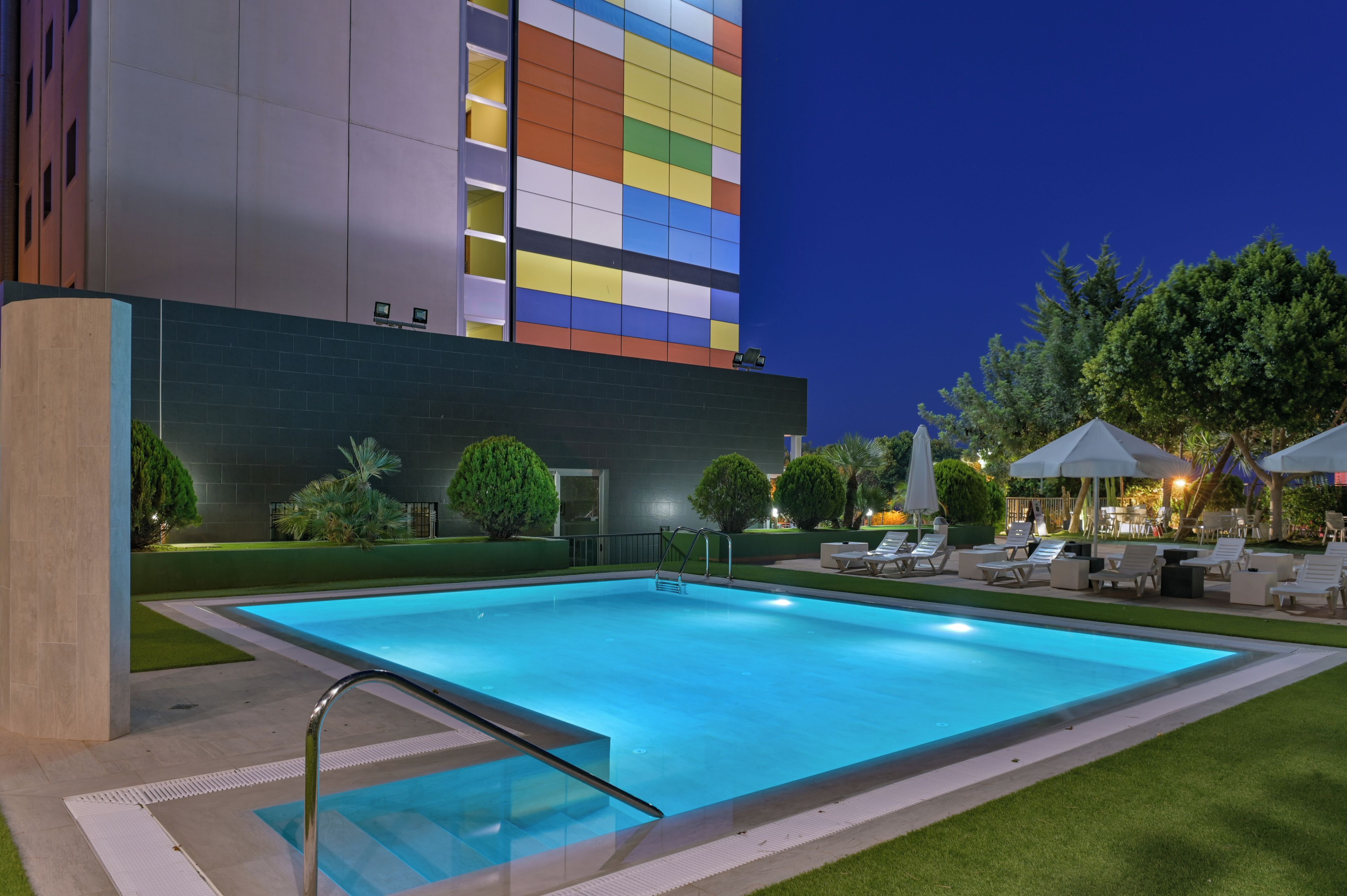 A swimming pool with a modern building in the background.