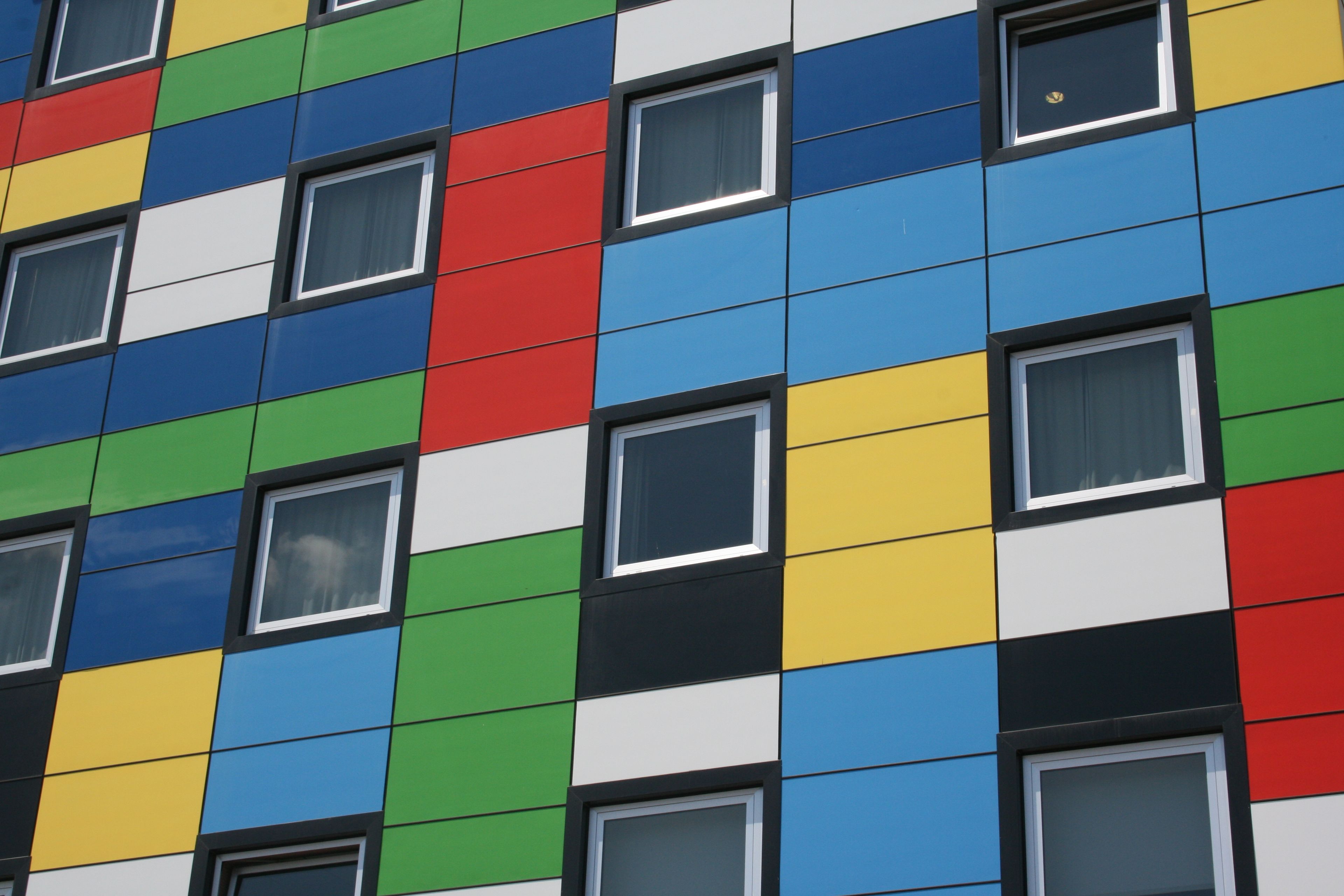 A building facade with a grid of windows and a colorful, multicolored pattern.