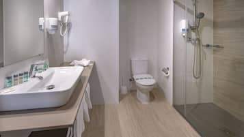 A modern bathroom with a sink, toilet, and shower.