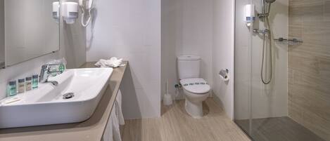 A modern bathroom with a sink, toilet, and shower.