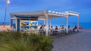 A beach bar with outdoor seating and a view of the sea. - 4R Miramar Calafell (Calafell)