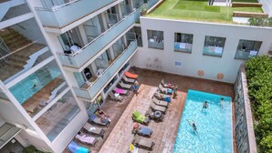 A multi-story hotel with a rooftop garden, a swimming pool, and outdoor seating areas. - 4R Miramar Calafell (Calafell)