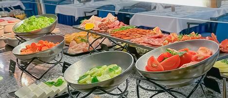 A buffet with various food options including vegetables, meats, and seafood.