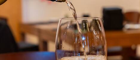 A bottle of wine being poured into a glass.