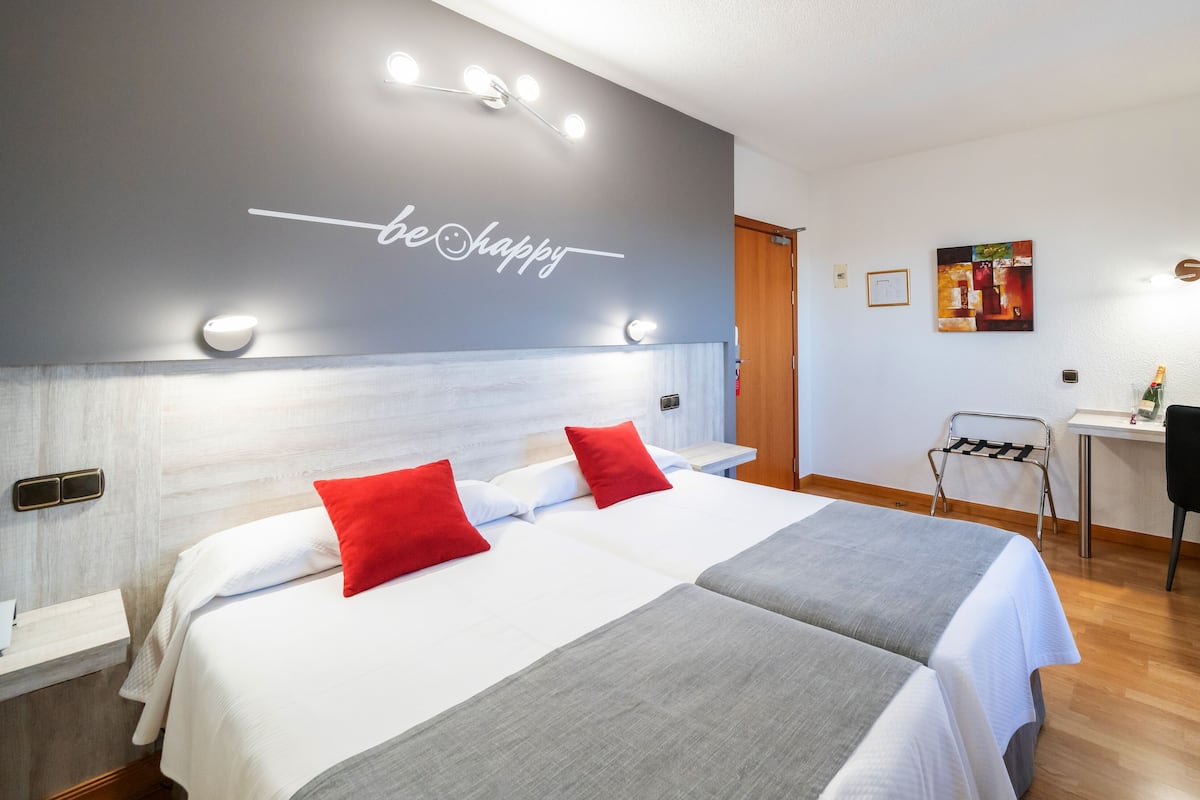 Une chambre d’hôtel avec un grand lit, un bureau et une chaise.