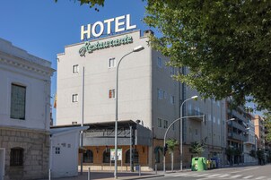 Un edificio de hotel con un letrero que dice "HOTEL Restaurante" y un acceso cubierto.