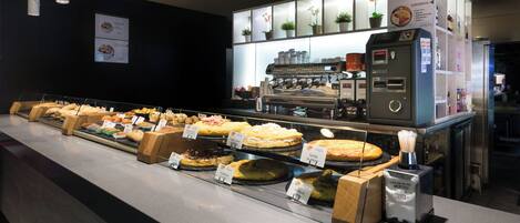 A bakery display with various baked goods and a coffee machine.