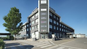 A modern hotel with a prominent sign indicating amenities such as a 24-hour cafeteria, buffet restaurant, and kart racing. - Hotel Luze El Villa (Castejón)