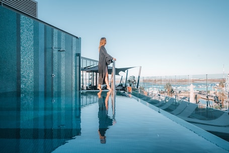 Una piscina al aire libre, sillones reclinables de piscina