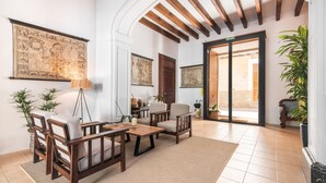 A spacious lobby with wooden furniture, a large map on the wall, and a view to the outside. -  Hotel Can Moragues (Arta)