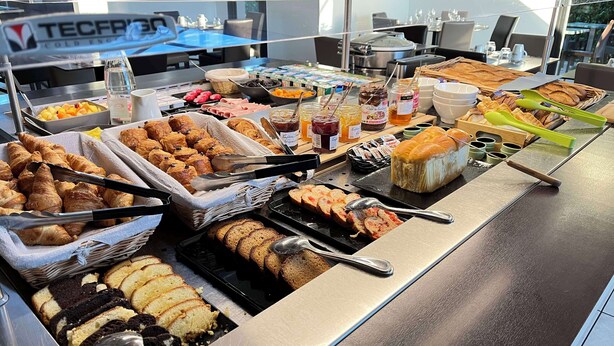 Un buffet proposant une variété de plats, notamment des pâtisseries, du pain et des condiments.