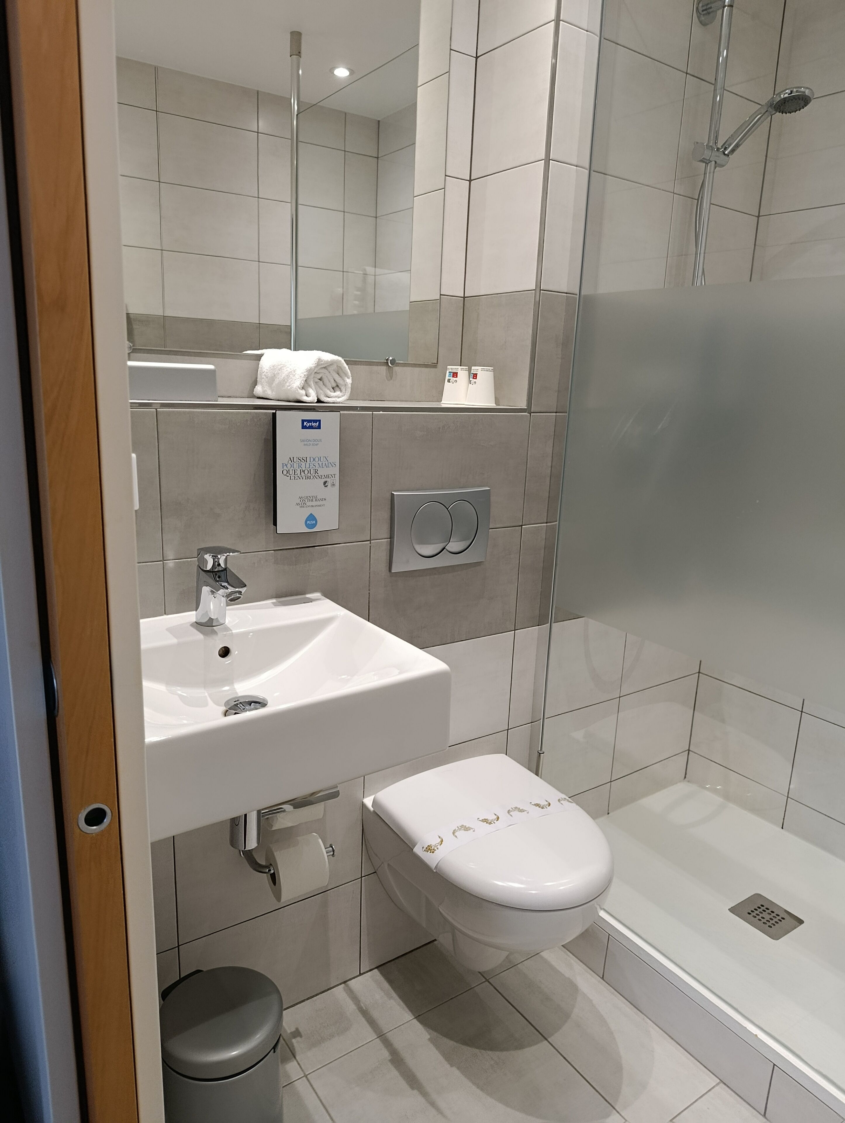 A modern bathroom with a white sink, toilet, and shower.