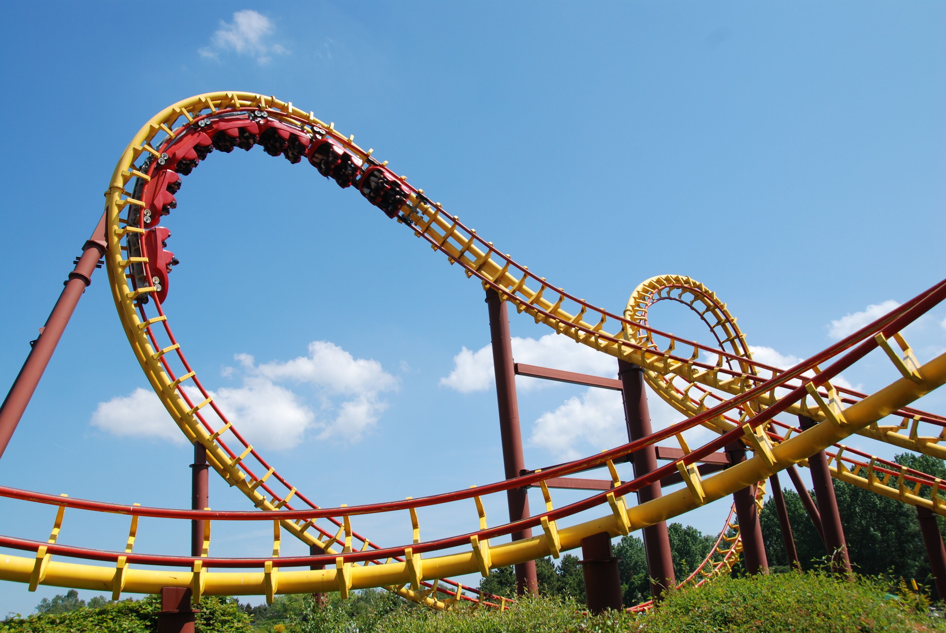 A roller coaster with a curved track and a clear blue sky in the background.