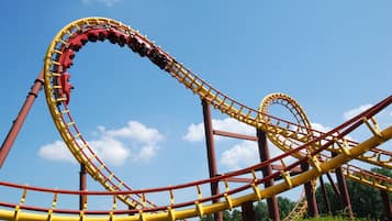 A roller coaster with a curved track and a clear blue sky in the background.