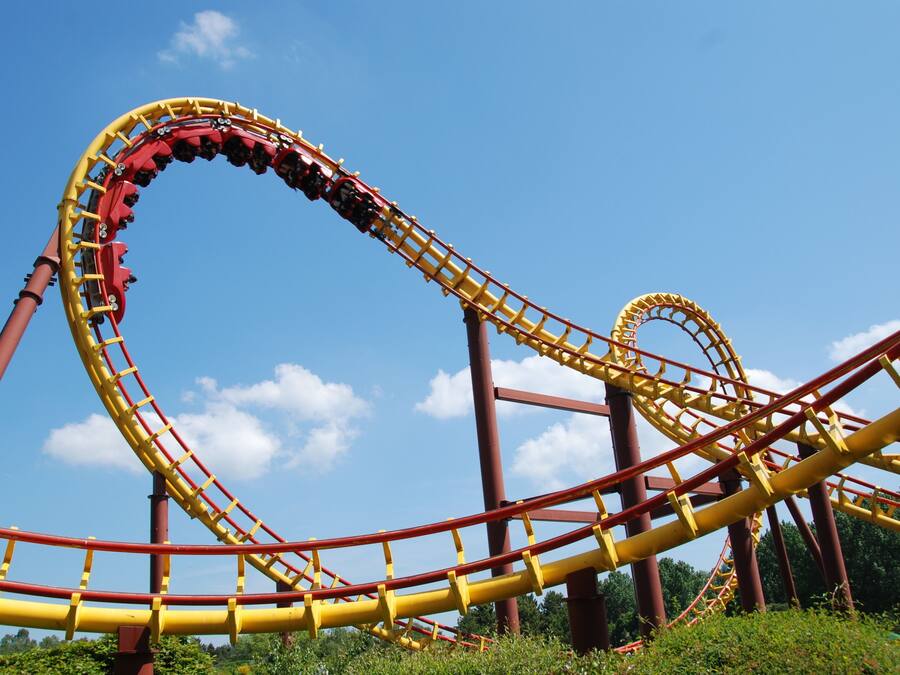 A roller coaster with a curved track and a clear blue sky in the background.