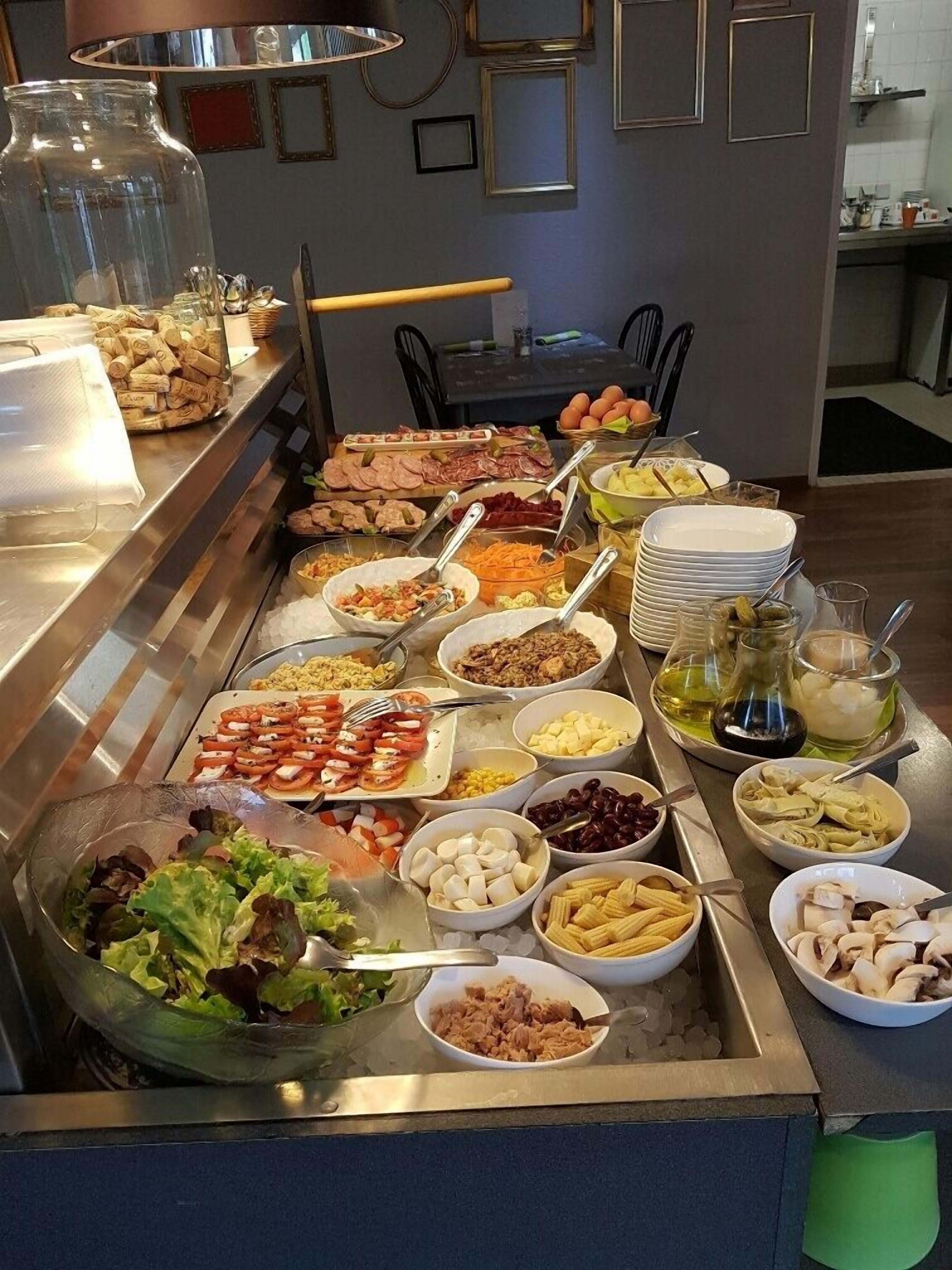 A buffet with various food items and a salad bowl.