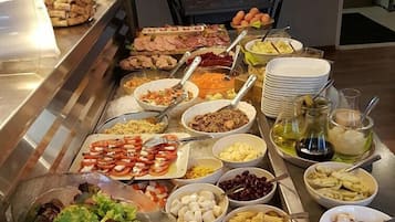 A buffet with various food items and a salad bowl.