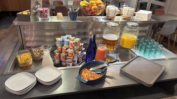 Un buffet proposant une variété de plats, de boissons et d’ustensiles.