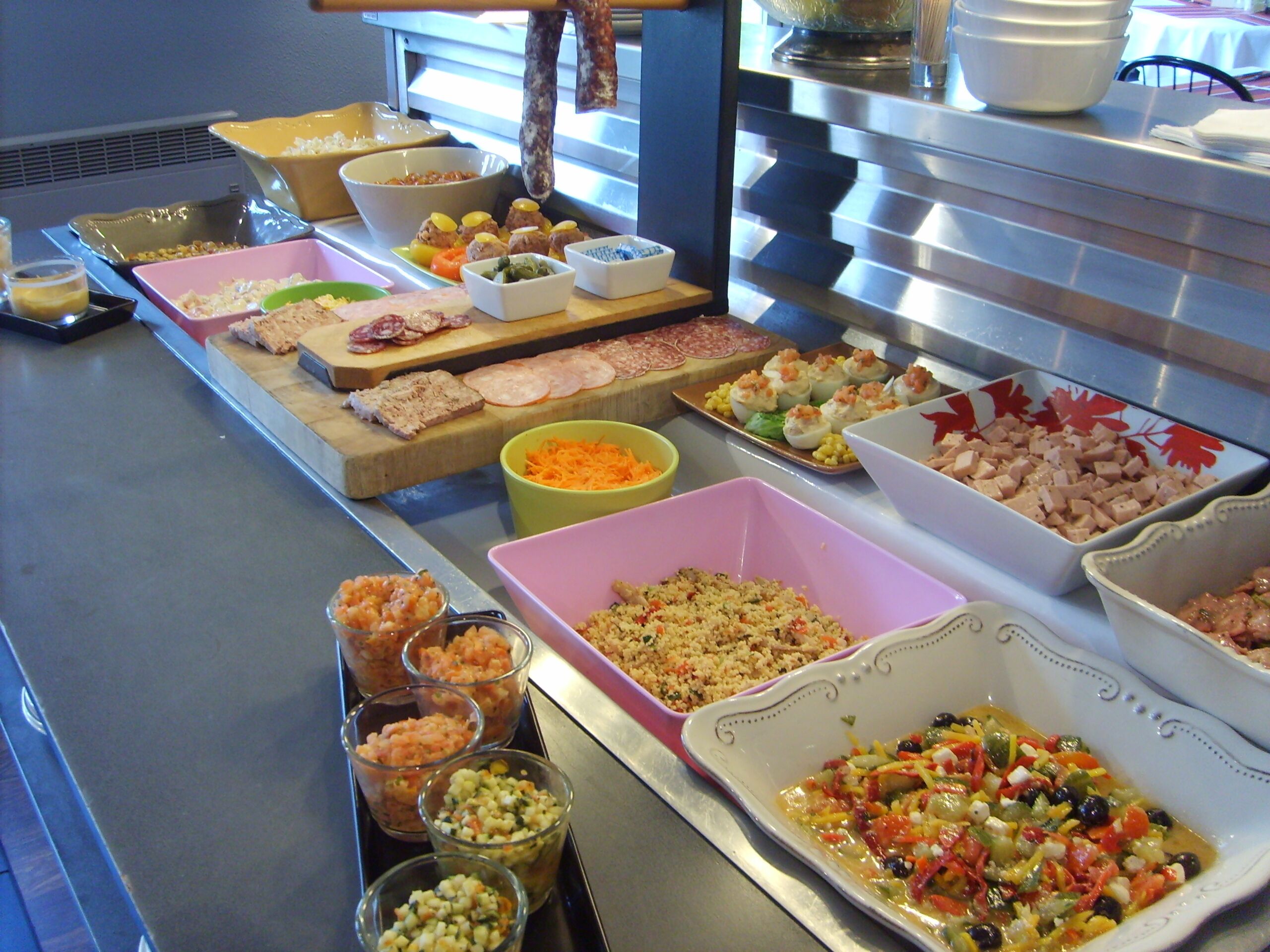 A buffet table with various food items and dishes.