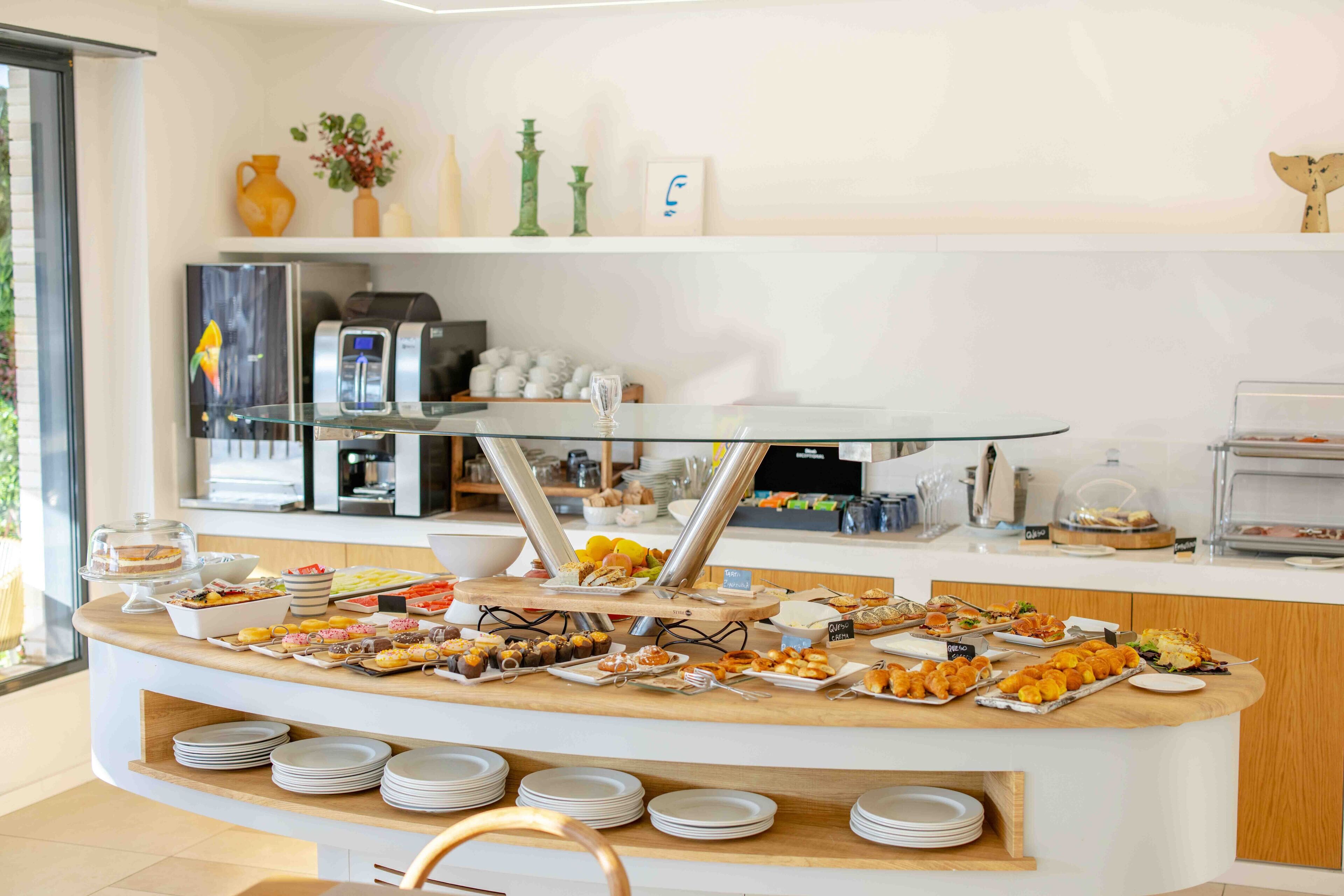 Een buffetopstelling met diverse gerechten, een koffieapparaat en een koffiekan.