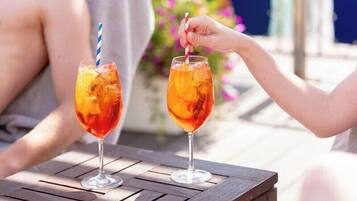 Two glasses of iced tea on a wooden table with a striped straw.