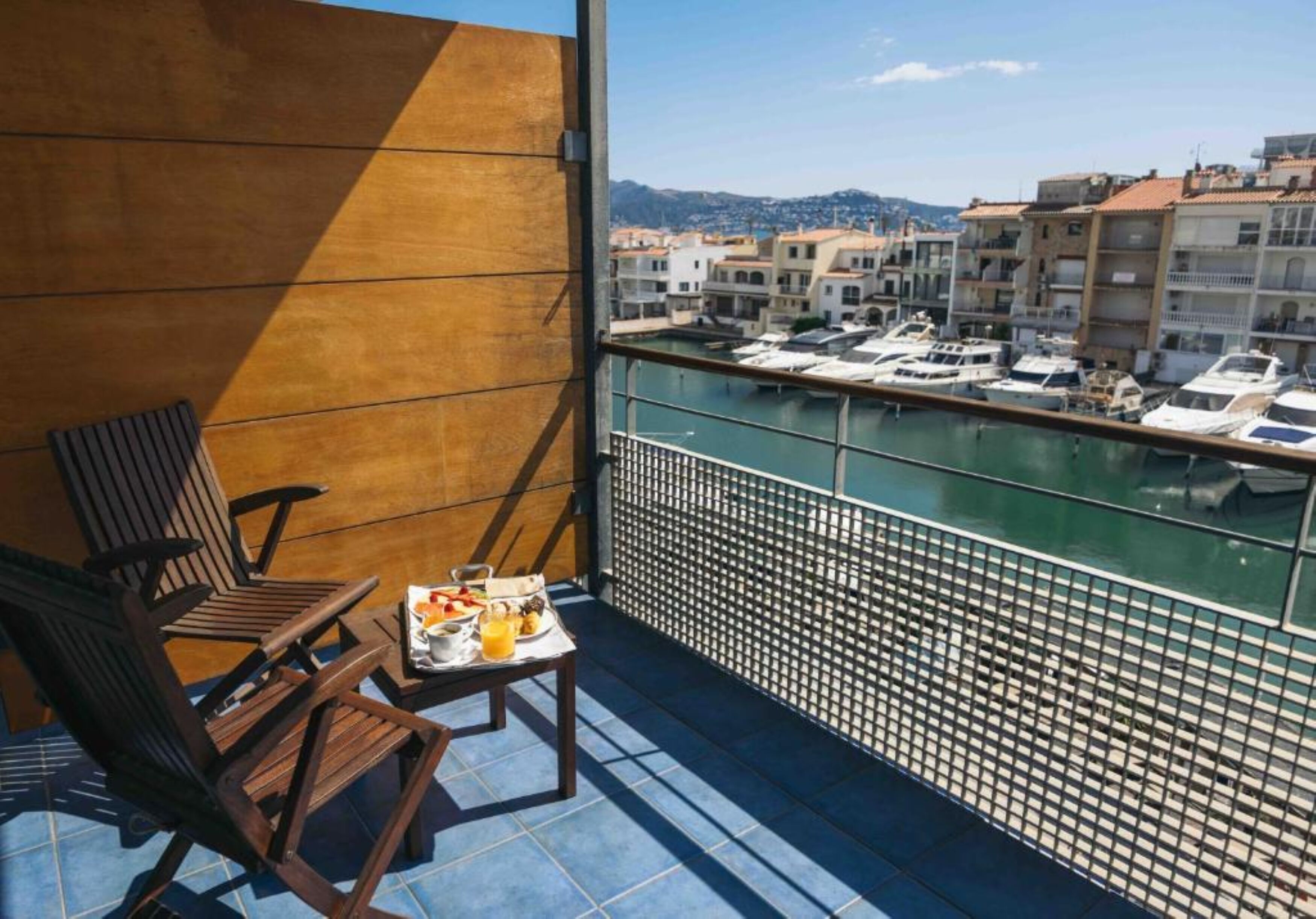 Un balcone con vista su un porto turistico e degli edifici.