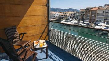 Un balcone con vista su un porto turistico e degli edifici.