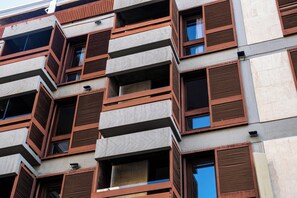 A multi-story building with a modern architectural design, featuring balconies with wooden railings and large windows. - Hotel Adonis Plaza (Santa Cruz de Tenerife)