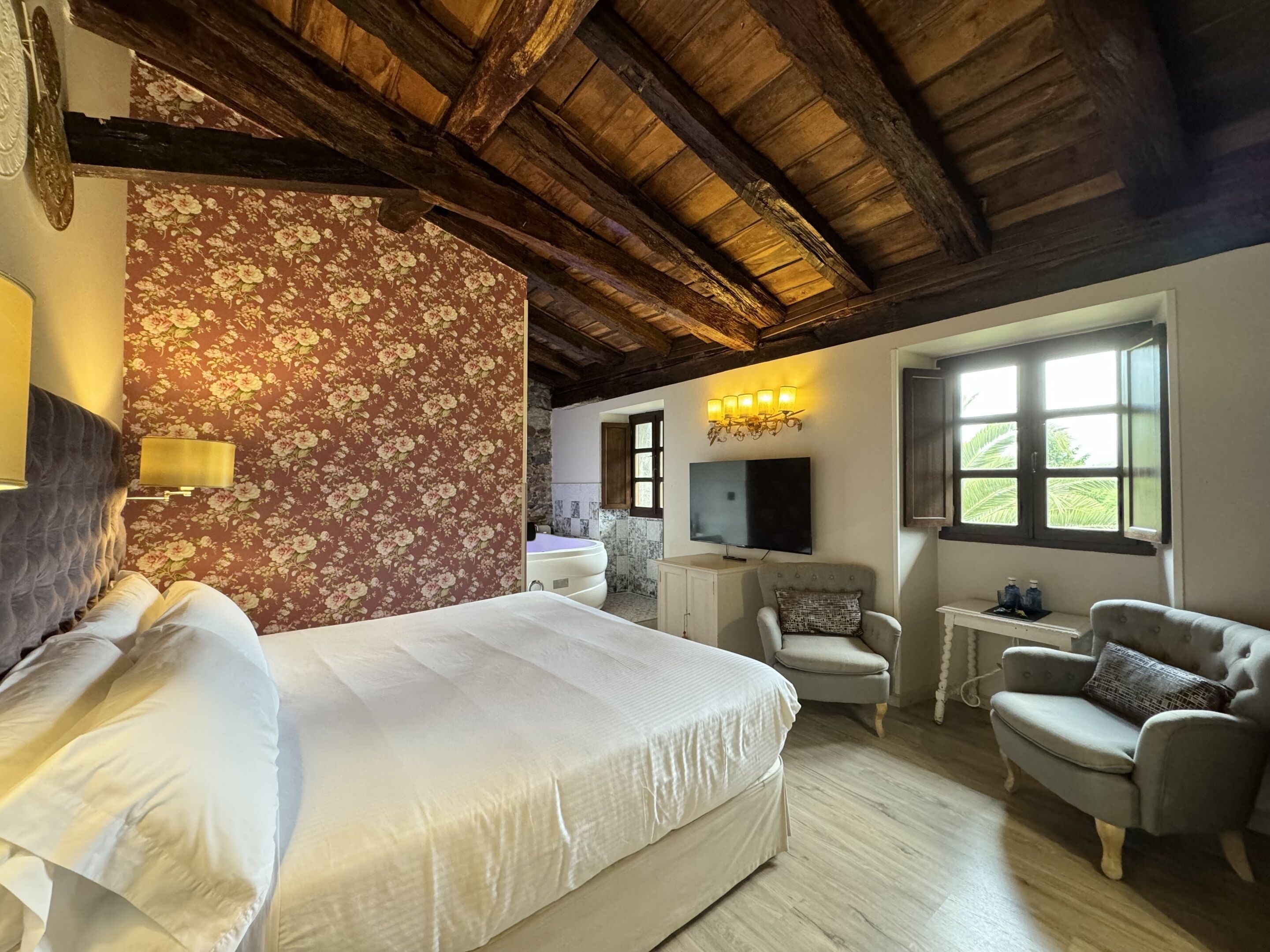 Ein Schlafzimmer mit einem Bett, einem Sessel, einem Fernseher und einem Fenster.