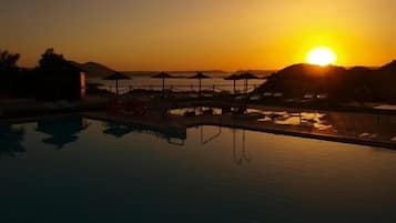 Una piscina al aire libre de temporada, sombrillas