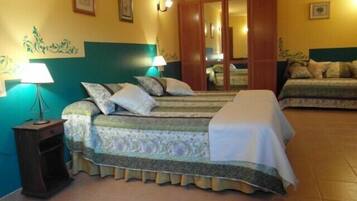 A hotel room with two beds, a nightstand, a lamp, and a mirror.