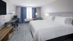 A hotel room with a bed, desk, chair, and a television. - Garner Auburn - Seattle by IHG (Auburn)