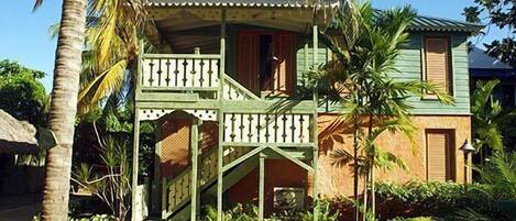 A two-story house with a balcony and a staircase leading to the upper floor.