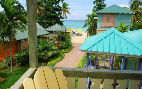 A beach view with a pathway leading to beach umbrellas and lounge chairs.