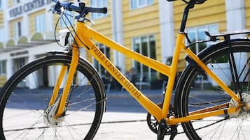 En gul cykel står parkerad framför en byggnad med en skylt som visar texten "Velle Center Hotel".