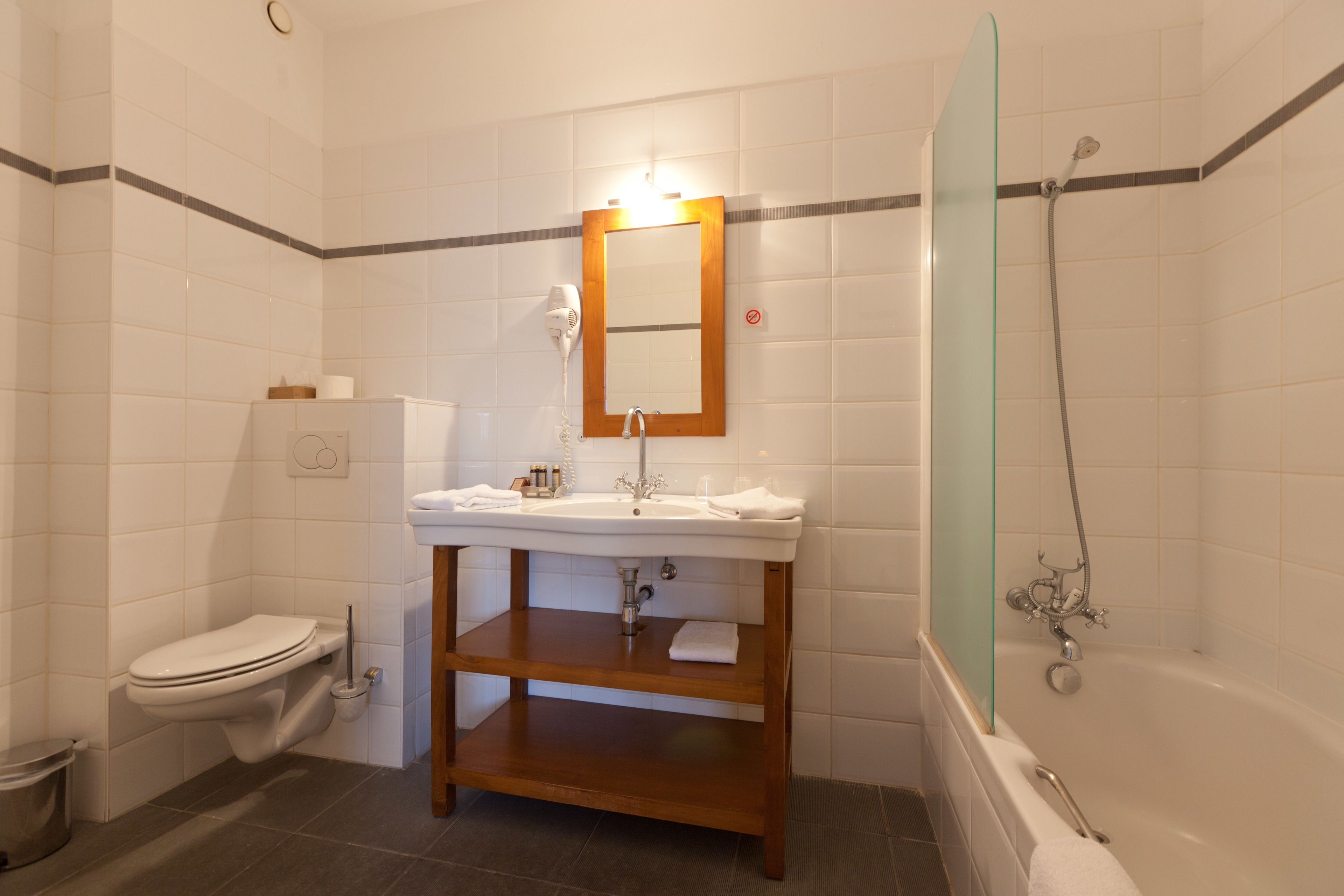 Une salle de bain avec des toilettes, un lavabo et une douche.