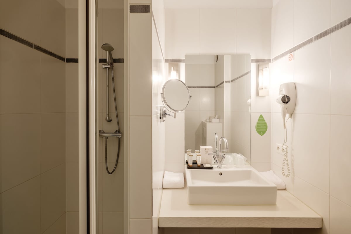 Badkamer | Een bad/douchecombinatie, een regendouche, gratis toiletartikelen