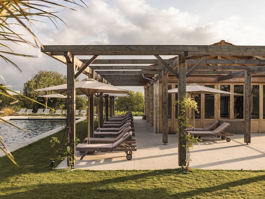 Una piscina al aire libre de temporada, sombrillas