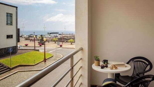 A balcony with a view of a parking area and a beach. - Hotel do Mar (Povoacao)