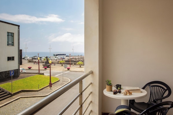 Un balcón con vista a un estacionamiento y una playa.