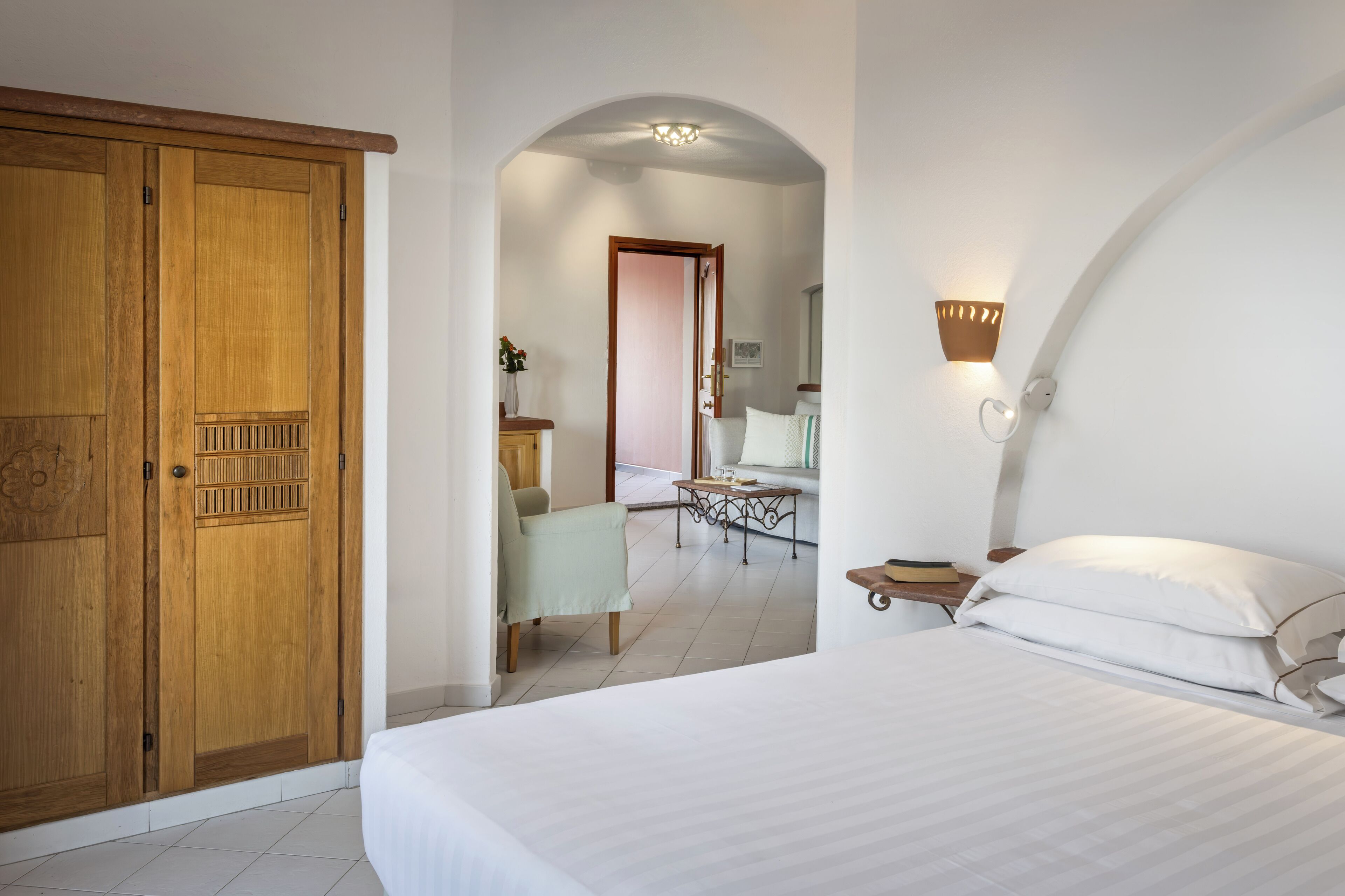 Una camera da letto con un letto, un'armadiatura in legno e un tavolino con una sedia.