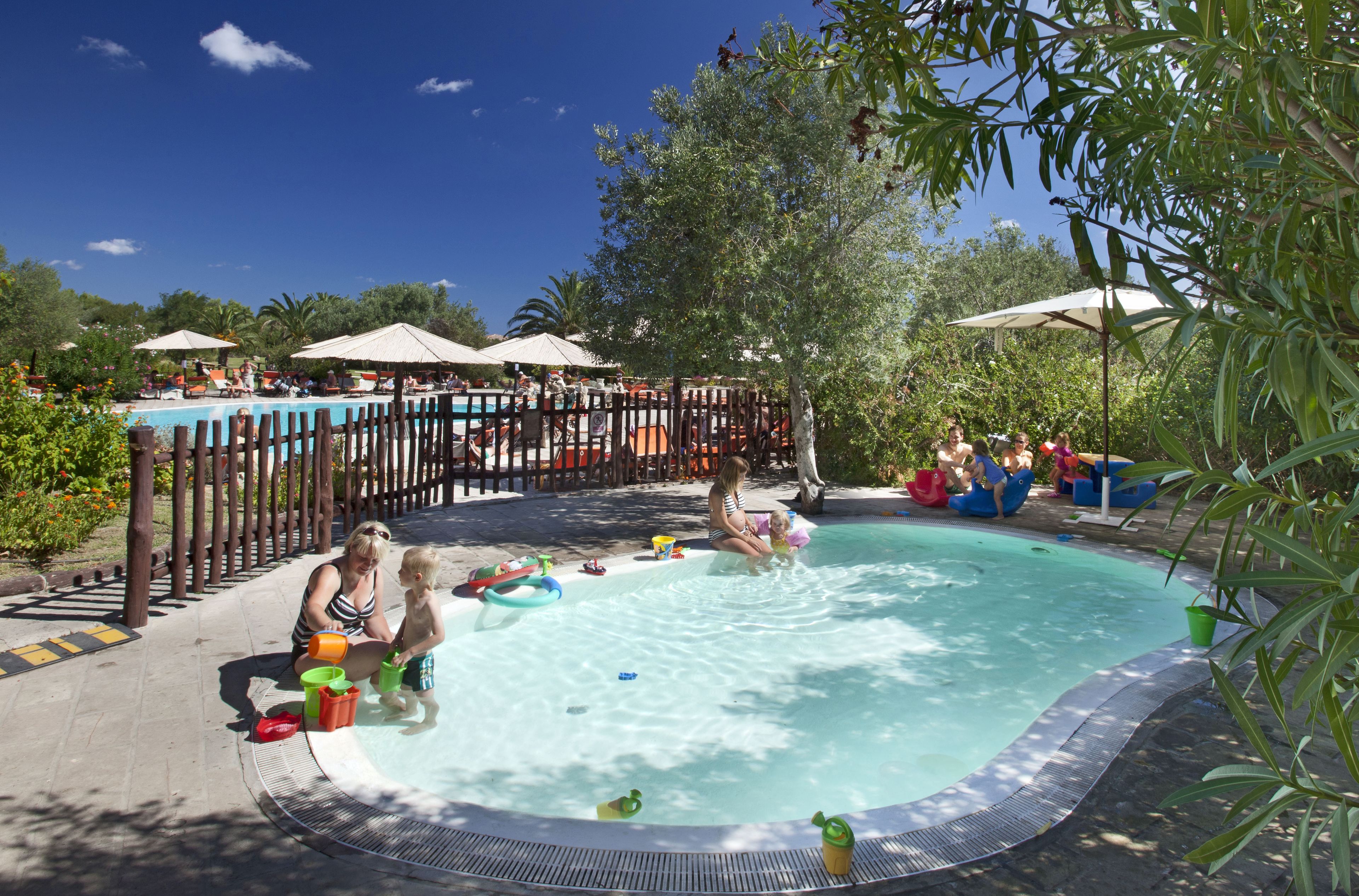 Una piscina al aire libre de temporada, sillones reclinables de piscina