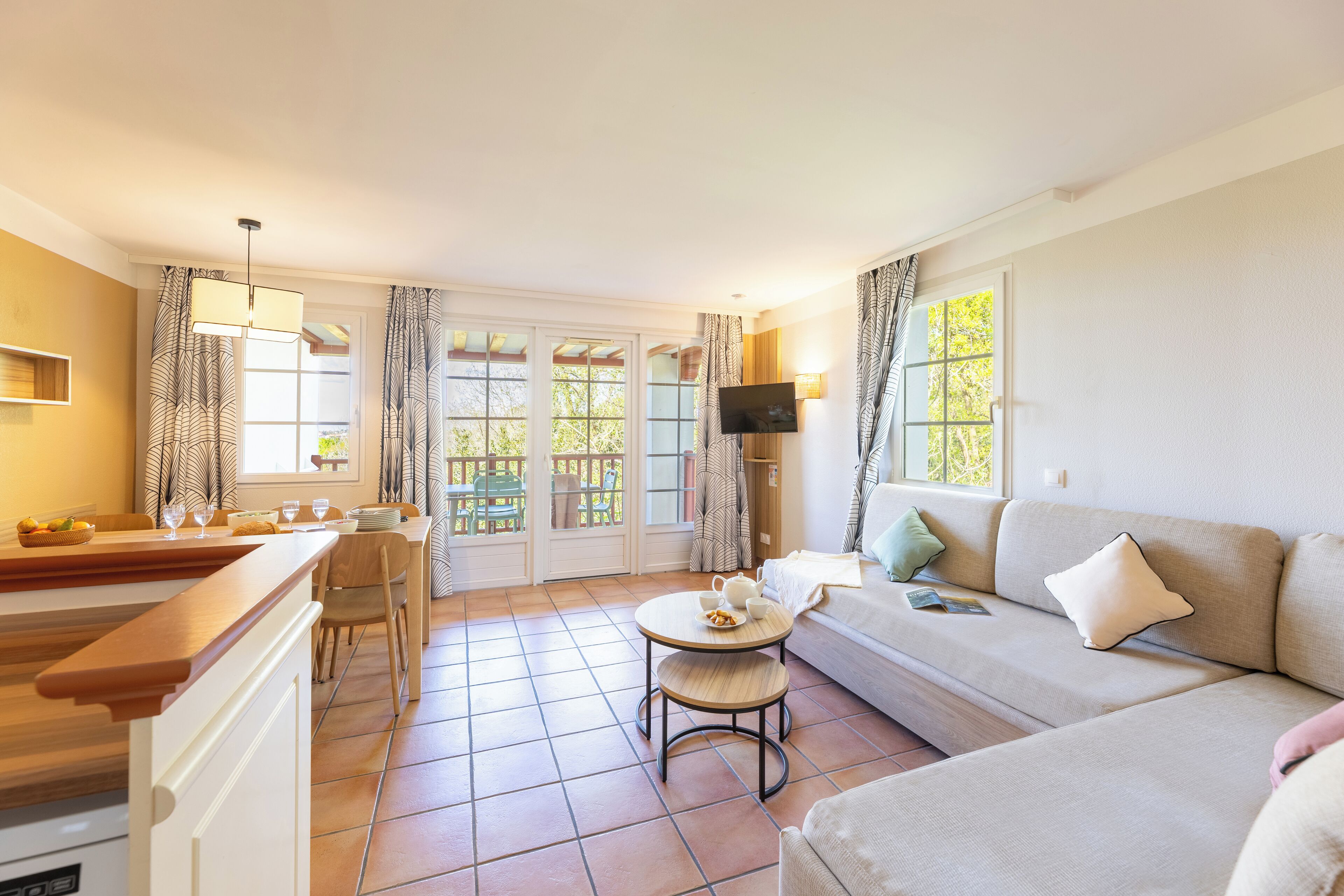 Een moderne woonkamer met een bank, een eettafel en een keukenhoek.