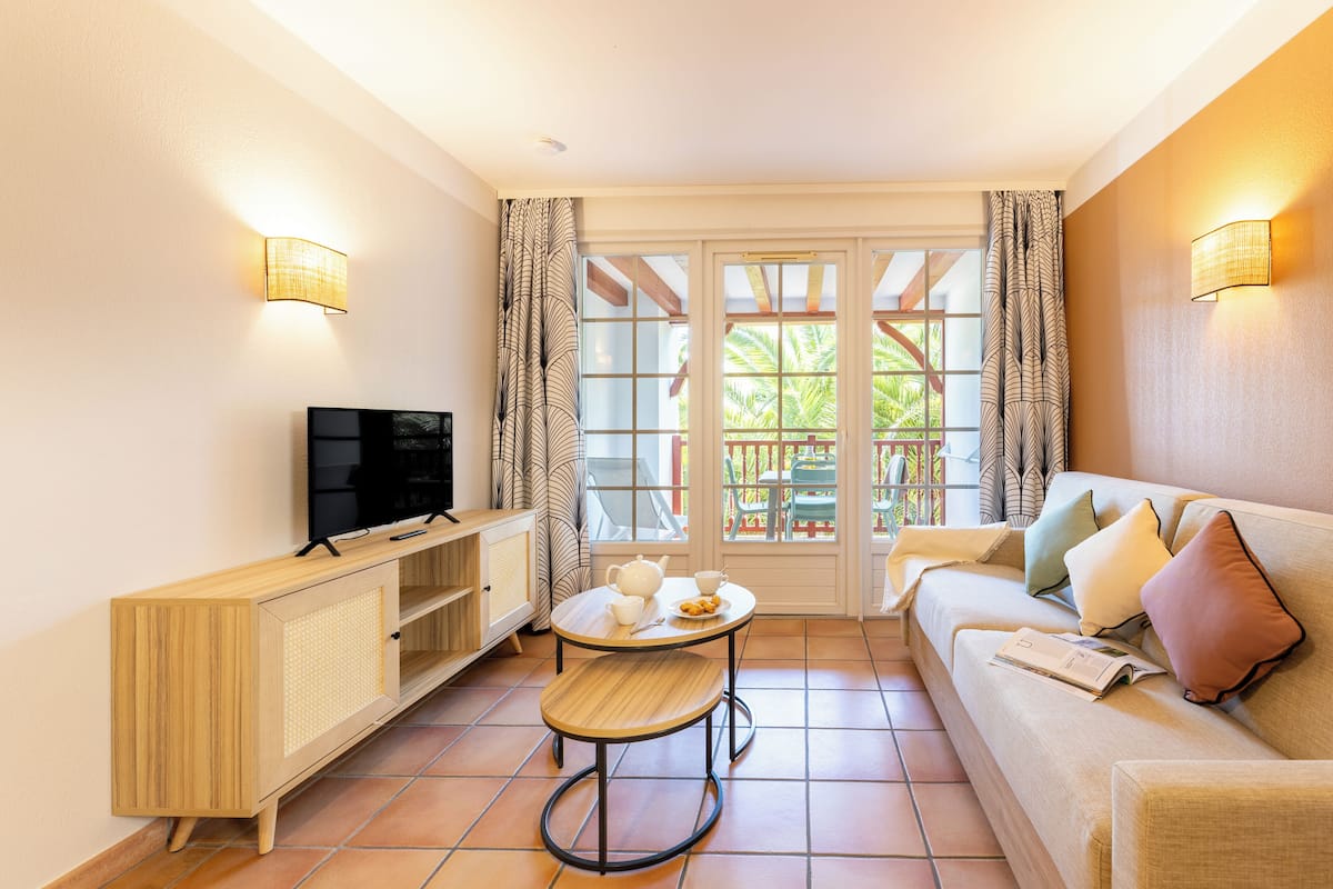 Appartement, 1 slaapkamer | Woonruimte | Flatscreentelevisie en boeken
