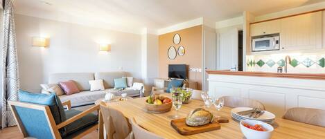 Una cocina moderna con una mesa de comedor de madera, sillas y un microondas.